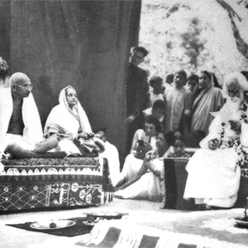 Tagore (at right, on the dais) hosts Mahatma Gandhi and wife Kasturba at Santiniketan